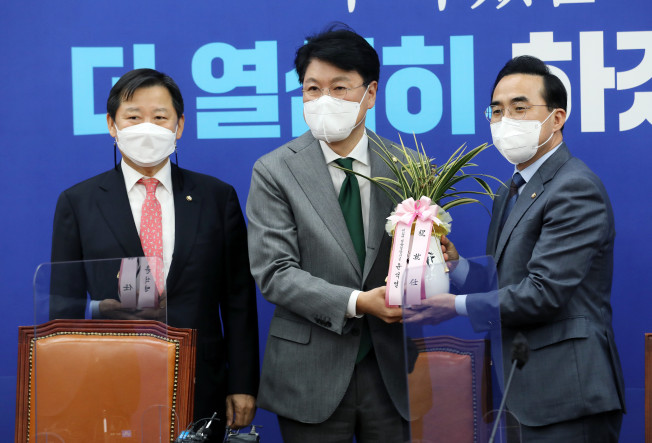 ▲더불어민주당 박홍근 신임 원내대표(오른쪽)가 25일 서울 여의도 국회 원내대표 회의실에서 장제원 대통령 당선인 비서실장으로부터 윤석열 대통령 당선인의 축하 난을 받고 있다. 오른쪽부터 박홍근 신임 원내대표, 장제원 비서실장, 이철규 국민의힘 의원.  (연합뉴스)