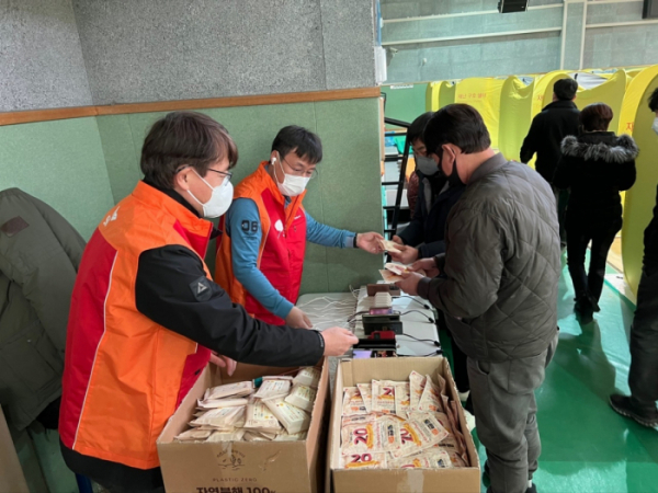 ▲SK텔레콤 직원들이 울진국민체육센터에 설치된 대피소에서 주민들에게 구호 물품을 나눠주고 있다. (사진제공=SK텔레콤)