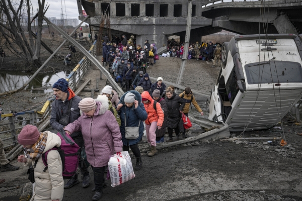 ▲우크라이나 이르핀에서 5일(현지시간) 주민들이 러시아군의 공습으로 부서진 다리 밑을 지나 피란길에 나서고 있다. 이르핀/AP연합뉴스 
