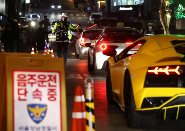 ▲식당 영업시간이 오후 11시까지 조정된 이후 첫 금요일을 맞은 11일 밤 서울 강남구 압구정동 유흥가에서 경찰이 음주 운전 단속을 하고 있다. 뉴시스