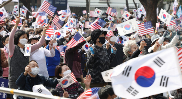 ▲코로나19 신규 확진이 팬데믹 이후 최다를 기록한 12일 오후 서울 중구 감리교 회관 앞에서 전광훈 사랑제일교회 담임 목사가 대표로 있는 국민혁명당 주최로 열린 1천만 자유 통일 기도회에서 참석자들이 태극기와 성조기를 흔들며 찬송을 부르고 있다.  (사진=연합뉴스)