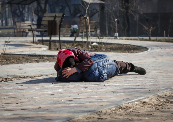 ▲우크라이나 남부 항구도시 마리우폴에서 23일(현지시간) 길 가던 여성이 포격 소리에 아들을 몸으로 감싼 채 땅에 엎드려 있다. 마리우폴/로이터연합뉴스
