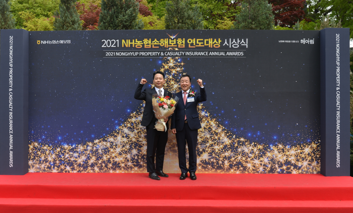 ▲NH농협손해보험은 서울 중구 소재 신라호텔에서 ‘2021 연도대상 시상식’을 개최했다고 22일 밝혔다. NH농협손보 최문섭 대표(사진 오른쪽)가 대상 수상자인 서서울농협 백대근 과장(사진 왼쪽)과 기념촬영을 하고 있다.