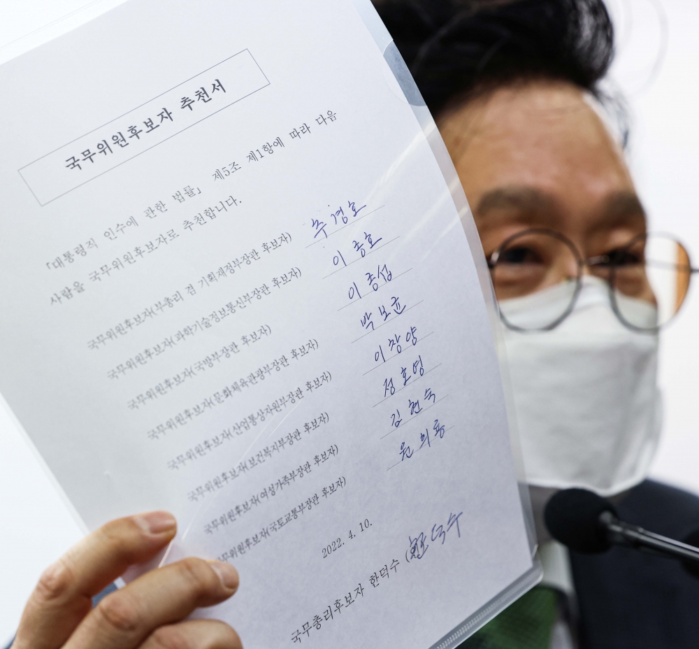 ▲ 원일희  제20대 대통령직인수위 수석대변인이 10일 오후 서울 종로구 통의동 인수위에서 윤석열 당선인의 초대 내각 명단을 발표 기자회견이 끝난 뒤 한덕수 총리 후보자가 서명한 국무위원후보자 추천서를 공개하고 있다.  인수위사진기자단  (이투데이DB)