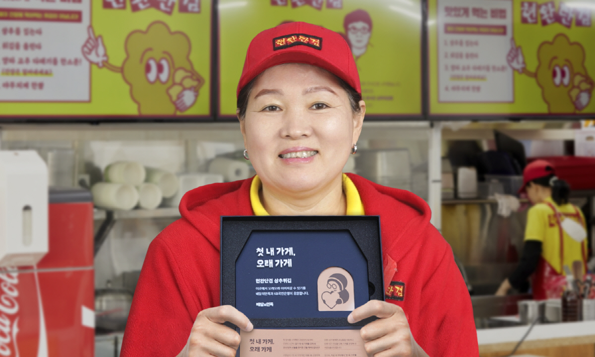 ▲우아한형제들의 소상공인 가게 구입 자금 지원 프로그램 ‘첫 내 가게 마련 대출’ 에 선정된 ‘현완단겸 상추튀김’ 제갈아미 사장이 가게 현판을 들고 있다. (사진제공=우아한형제들)