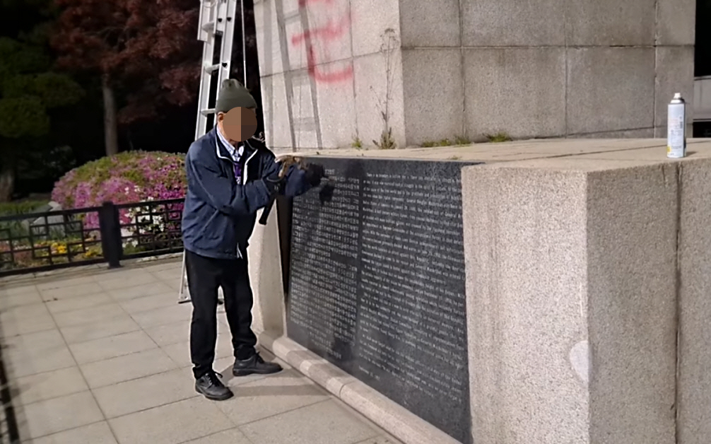 ▲평화협정운동본부 소속 A 씨가 28일 인천시 중구 송학동 자유공원 내 맥아더 동상의 전쟁 공적비를 훼손하고 있다. (출처=평화협정운동본부 페이스북)