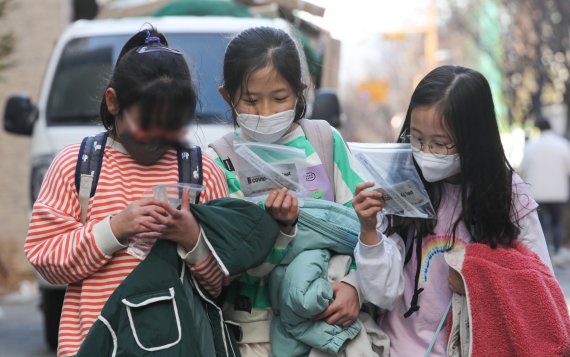 ▲새학기 전면 등교 첫날인 2일 오후 서울 시내 초등학교에서 학생들이 자가진단키트를 살펴보며 하교하고 있다.  (뉴시스)