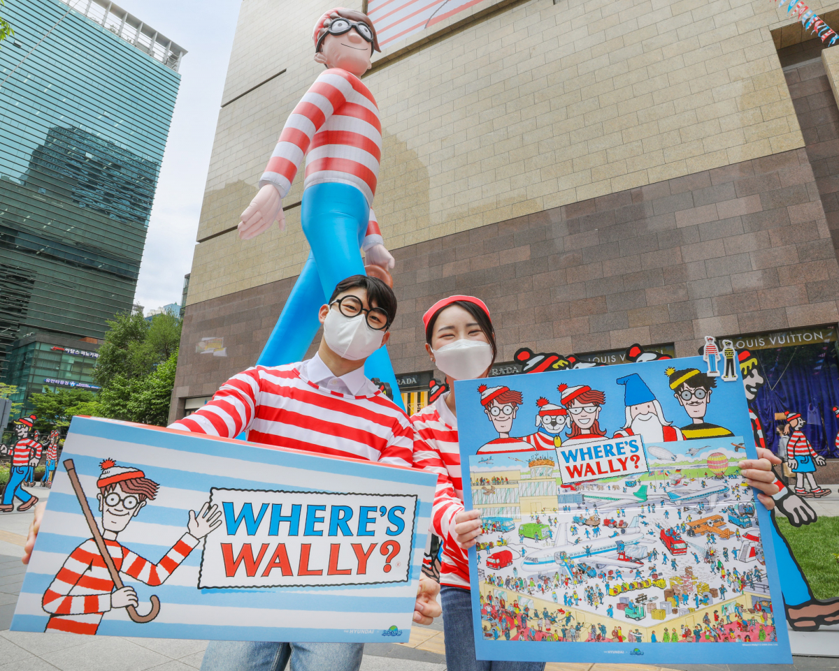 ▲1일 오전 서울 강남구에 위치한 현대백화점 무역센터점 정문에 설치된 대형 벌룬 월리 앞에서 직원들이 다양한 월리 콜라보 굿즈 상품을 선보이고 있다. (사진제공=현대백화점)