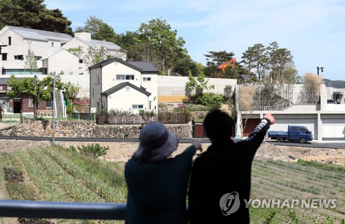 ▲문재인 대통령 내외 귀향을 하루 앞둔 9일 오후 경남 양산시 하북면 평산마을을 찾은 시민이 대통령 사저 및 경호 시설을 멀리서 관찰하고 있다. 문재인 대통령 내외는 이날 임기를 마친 후 10일부터 양산 사저에서 거주한다.(연합뉴스)
