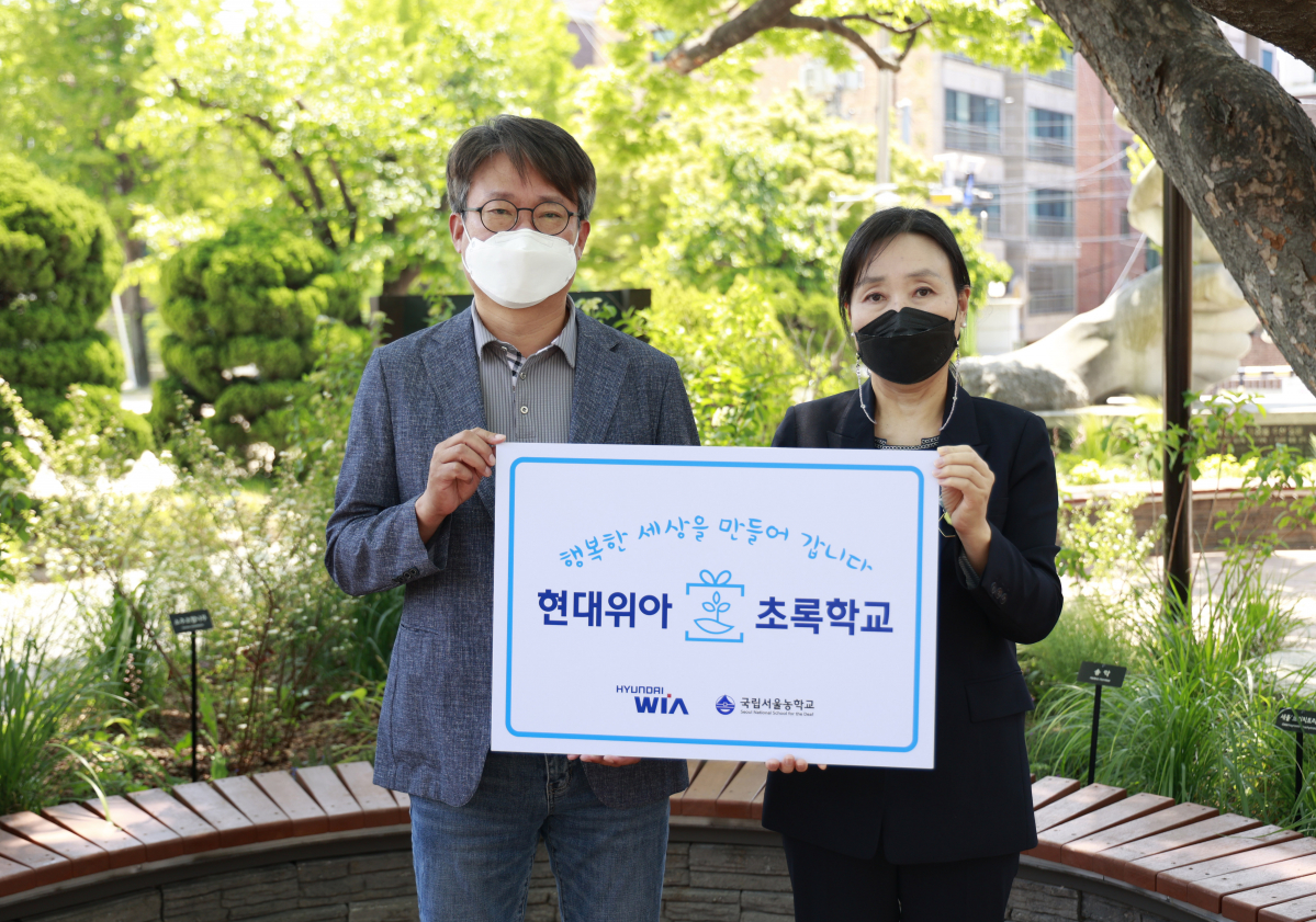 ▲원광민 현대위아 차량부품연구센터장과 김은숙 국립서울농학교 교장이 지난 10일 서울 종로구 국립서울농학교 내 현대위아가 조성한 ‘느티나무 정원’에서 기념사진을 찍고 있다. (사진제공=현대위아)