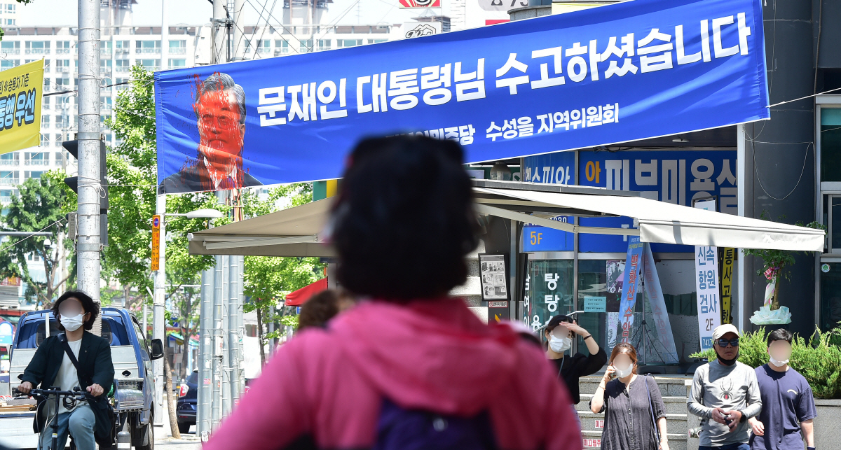 ▲11일 오전 수성구 수성시장네거리 일대에서 문 전 대통령의 퇴임 기념 현수막이 훼손된 채 시민들에게 목격됐다.(뉴시스)
