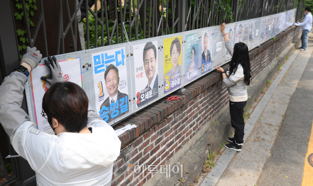 ▲선거관리위원회 관계자들이 6.1 지방선거 포스터를 붙이고 있다. ( 조현호 기자 hyunho@)