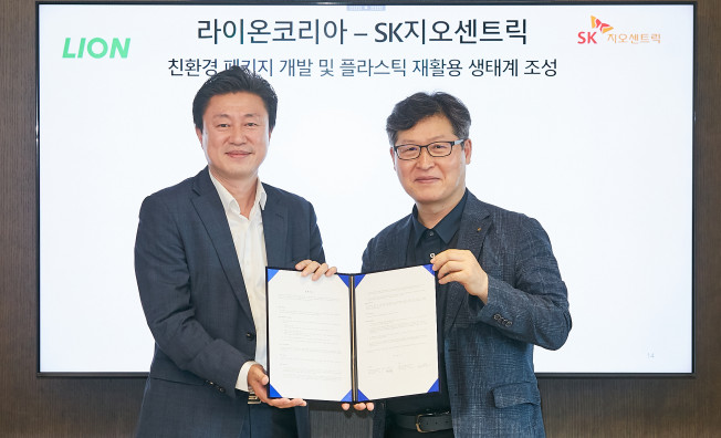 ▲SK지오센트릭 장남훈 패키징 본부장(왼쪽)과 라이온코리아 성민제 SCM&생산본부 상무가 업무협약 체결 후 기념촬영을 하고 있다. (사진제공=SK지오센트릭)