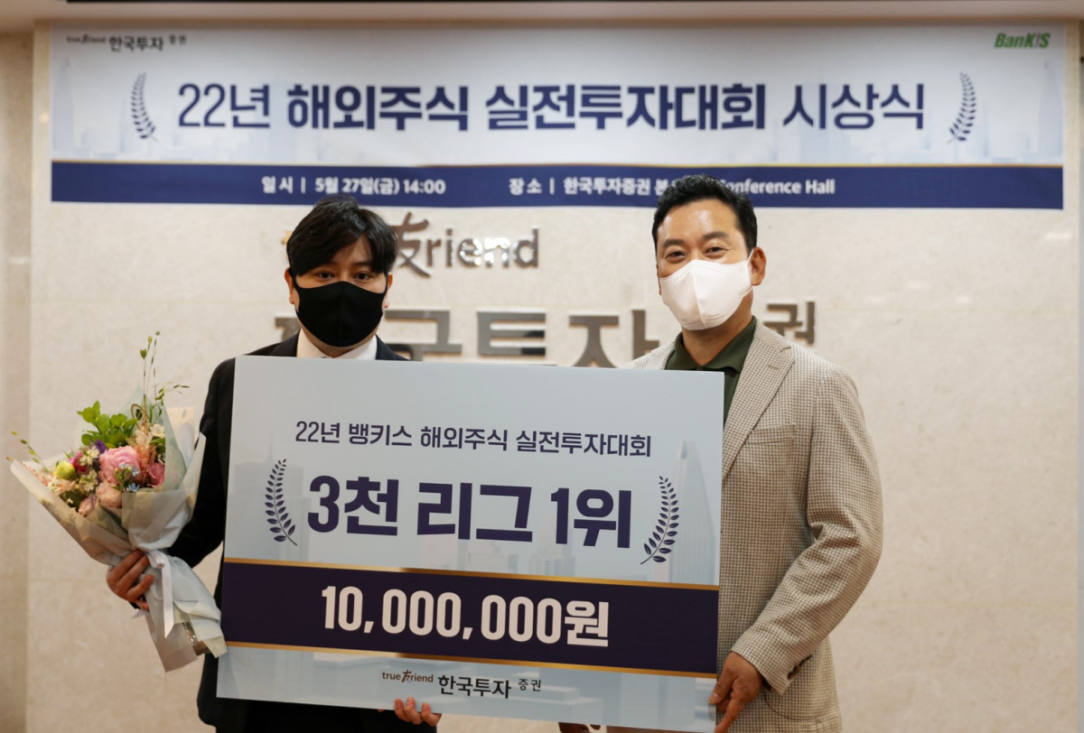 ▲지난 27일 서울 여의도 한국투자증권 본사에서 열린 '2022년 해외주식 실전투자대회' 시상식에서 김성환 개인고객그룹장(오른쪽)이 대회 기간 가장 높은 수익률을 기록한 김양호 씨에게 상금을 수여하고 기념 사진을 촬영하고 있다. (출처=한국투자증권)