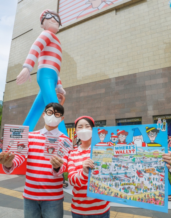 ▲1일 오전 서울 강남구에 위치한 현대백화점 무역센터점 정문에 설치된 대형 벌룬 월리 앞에서 직원들이 다양한 월리 콜라보 굿즈 상품을 선보이고 있다. (사진제공=현대백화점)
