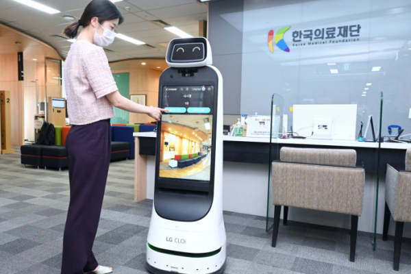 ▲한국의료재단 종합검진센터 직원이 LG 클로이 가이드봇을 활용해 건강검진 안내를 받는 모습을 시연하고 있다. (사진제공=LG전자)
