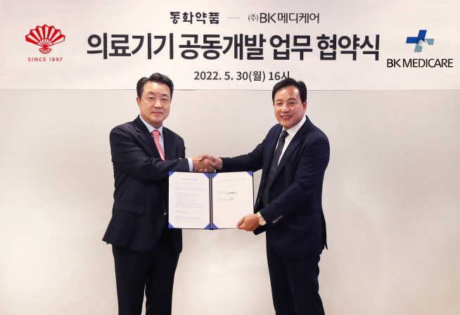 ▲한종현(왼쪽) 동화약품 사장과 박영준 BK메디케어 사장이 업무협약식에서 악수하고 있다. (사진제공=동화약품)