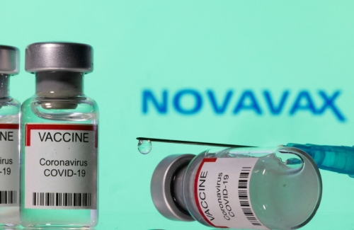 ▲미국 제약사 노바백스 로고를 배경으로 코로나19 백신이 놓여 있다. 로이터연합뉴스
