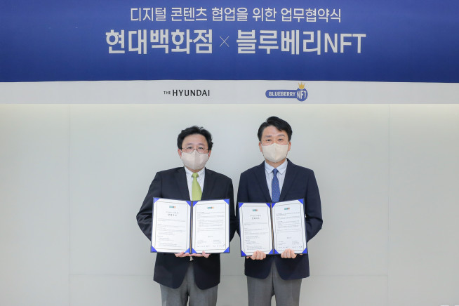 ▲9일 서울 강남구에 현대백화점 사옥에서 권태진 현대백화점 디지털사업본부장(오른쪽)과 홍상혁 블루베리NFT 대표이사가 MOU를 체결한 후 기념촬영을 하고 있다.(사진제공=현대백화점)