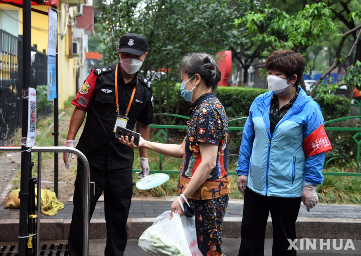▲중국 수도 베이징 하이뎬구 한 주택가에서 12일(현지시간) 주민이 코로나19 검사 결과 등이 담긴 건강 QR 코드를 보여주고 있다. 베이징/신화뉴시스