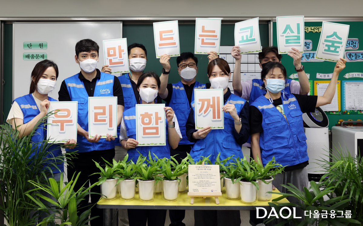 ▲다올금융그룹 봉사단 ‘밝은내일 서포터즈’가 15일 수원 신성초등학교에서 ‘교실 숲’ 조성을 위한 공기정화식물을 전달하고 기념촬영을 하고 있다.  (출처=다올투자증권)