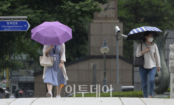 ▲갑작스런 소나기가 내린 13일 서울 중구 청계광장 인근에서 우산을 쓴 시민들이 발걸음을 재촉하고 있다. (조현호 기자 hyunho@)