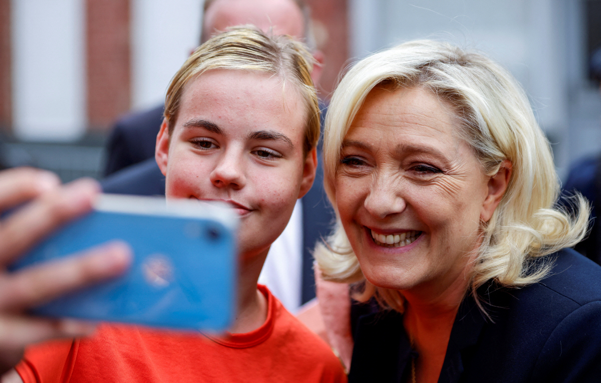▲마린 르펜 국민연합(RN) 대표가 19일(현지시간) 유권자와 사진을 찍고 있다. 에냉-보몽/로이터연합뉴스