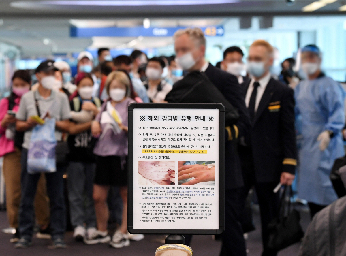 ▲27일 오전 인천국제공항 제1여객터미널 입국장에서 독일 프랑크푸르트와 우즈베키스탄발 탑승객들이 검역을 받기 위해 대기하고 있는 가운데 원숭이 두창 안내문이 게시되어 있다. (뉴시스)
