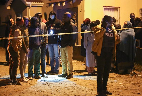 ▲26일(현지시간) 10대 20여명이 집단 의문사한 남아프리카공화국 이스트런던의 한 술집 앞에서 유가족들이 경찰의 발표를 기다리고 있다. AFP연합뉴스