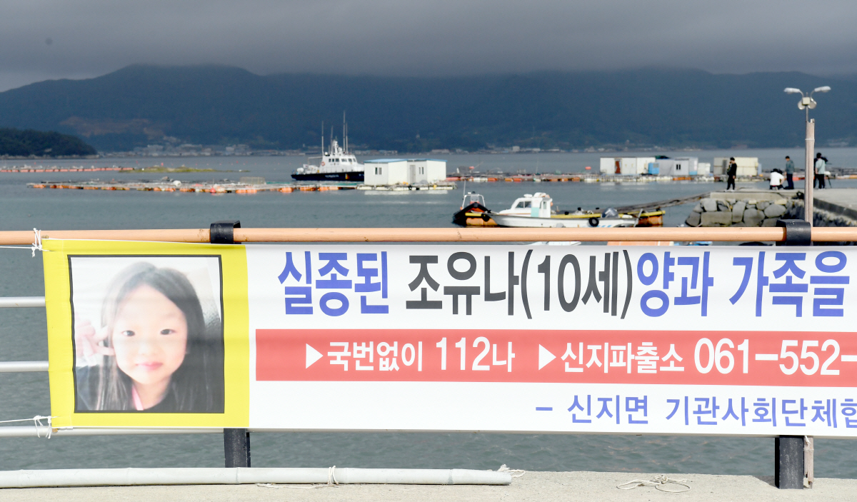 ▲한달째 행방을 알 수 없었던 초등학생 조유나양과 부모가 탑승했던 승용차량이 바다에서 발견돼 인양 작업이 진행되는  29일 오전 전남 완도군 신지면 송곡항 입구에 조양을 찾는 현수막이 걸려 있다.(뉴시스)
