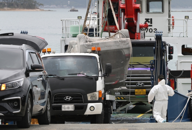 ▲29일 오전 전남 완도군 신지면 송곡선착장 부근에서 경찰이 10ｍ 바닷속에 잠겨있는 조모(10)양 가족의 차량을 인양한 뒤 조양 가족으로 추정되는 시신을 수습하고 있다. 경찰은 실종된 조양의 가족과 차량을 찾기 위해 수중 수색하다 전날 가두리양식장 아래에 잠겨있는 차량을 발견했다. (연합뉴스)
