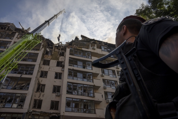 ▲우크라이나 키이우에서 26일(현지시간) 우크라이나군이 폭격 맞은 아파트를 올려다 보고 있다. 키이우/AP뉴시스
