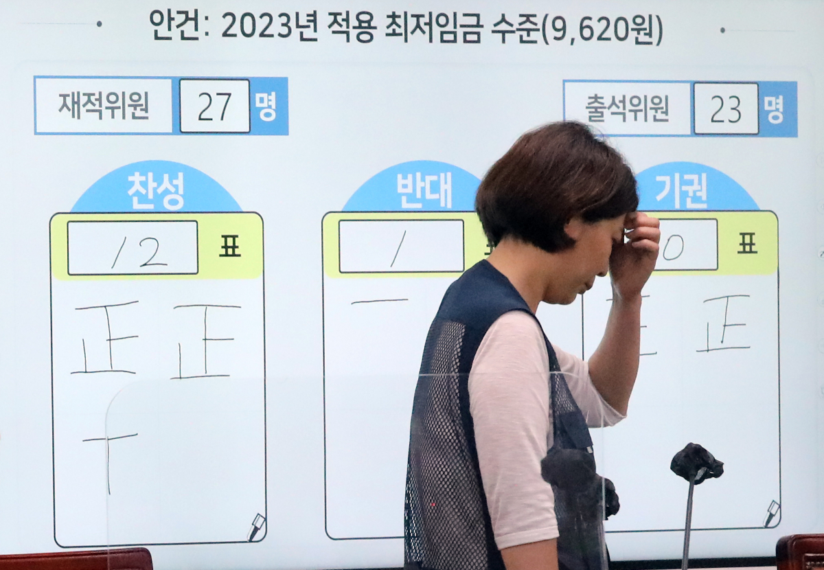 ▲6월 29일 밤 세종시 정부세종청사 최저임금위원회 전원회의장에서 한 참석자가 2023년도 적용 최저임금 심의를 마친 뒤 표결 결과 앞을 지나고 있다. (뉴시스)