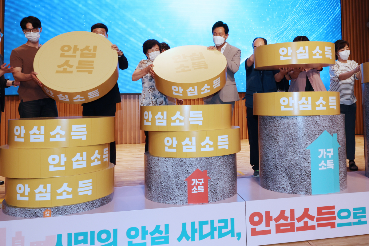 ▲ 오세훈 시장이 서울시청에서 열린 '서울 안심소득 시범사업 출범식'에서 사업 참여 가구로 선정된 시민들과 함께 퍼포먼스를 하고 있다. (연합뉴스)