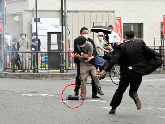 ▲(트위터 캡처) SNS 등을 통해 공개된 아베 신조 전 일본 총리 총기 피습범 야마가미 테츠야(41)의 체포 당시 사진, 발 아래(빨간 원) 피습에 사용된 것으로 보이는 총기가 떨어져있다.
