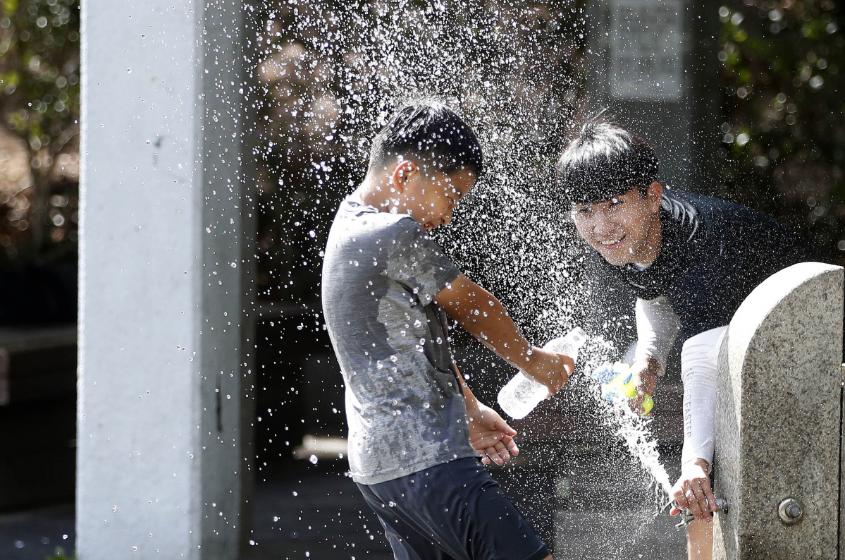 ▲광주 북구 일곡제1근린공원 축구장에서 놀던 학생들이 페트병에 물을 담아 뿌리며 장난치고 있다. (연합뉴스)
