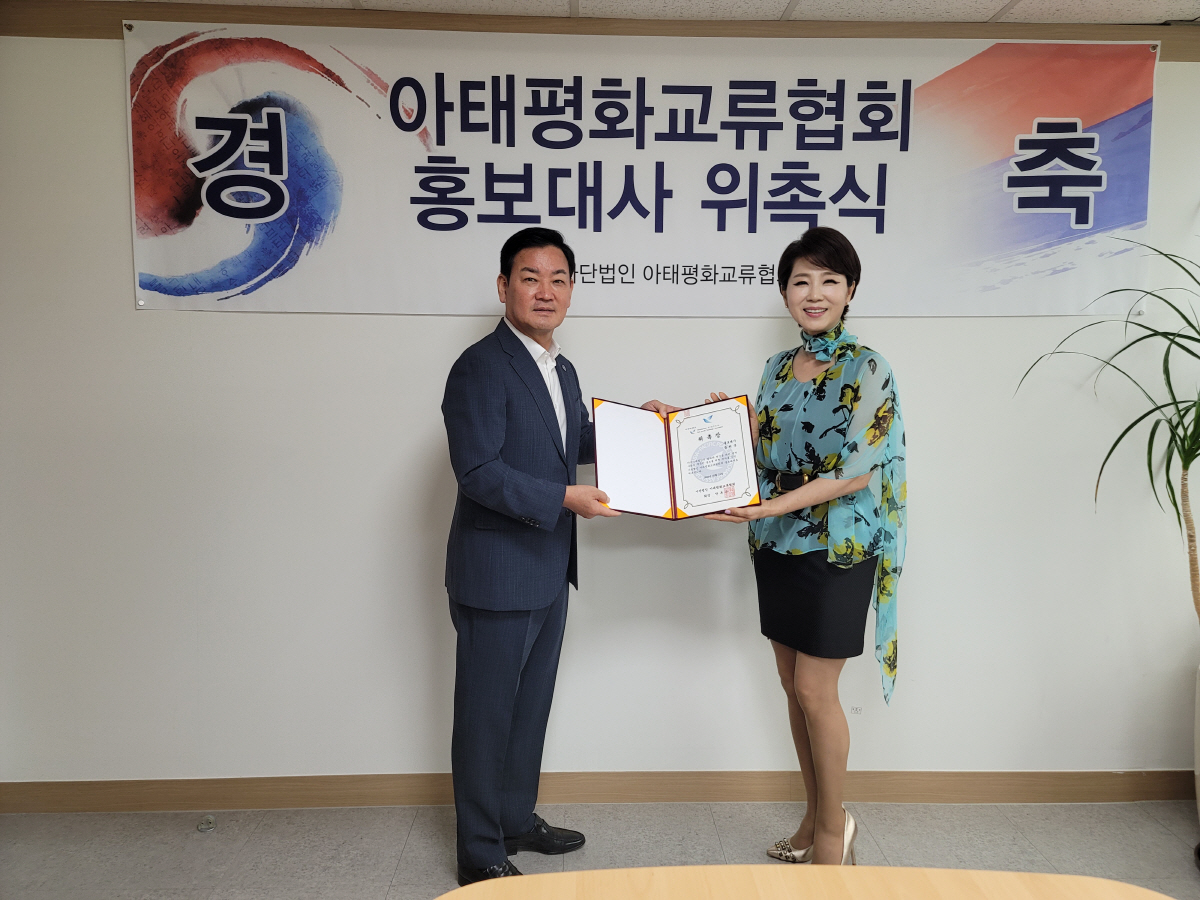 ▲가수 문희옥(오른쪽) 씨가 7월 12일 안부수 아태평화교류협회 협회장과 홍보대사 위촉식을 갖고 있다.