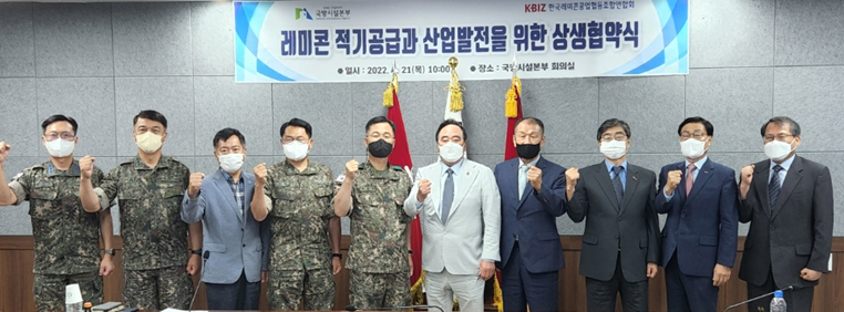 ▲김환철(왼쪽 다섯 번째부터)국방시설본부장, 배조웅 한국레미콘공업협동조합연합회장 등이 21일 국방시설본부 회의실에서 업무협약을 체결하고 기념촬영을 하고 있다. (사진제공=한국레미콘공업협동조합연합회)