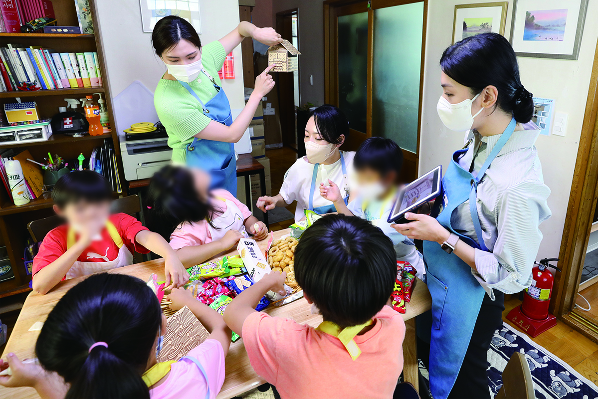 ▲지난 21일 오후 제주특별자치도 외도에 위치한 제주보육원에서 제주항공 객실승무원들이 초등학생 어린이들과 과자로 집모형을 만들고 있다. (사진제공=제주항공)