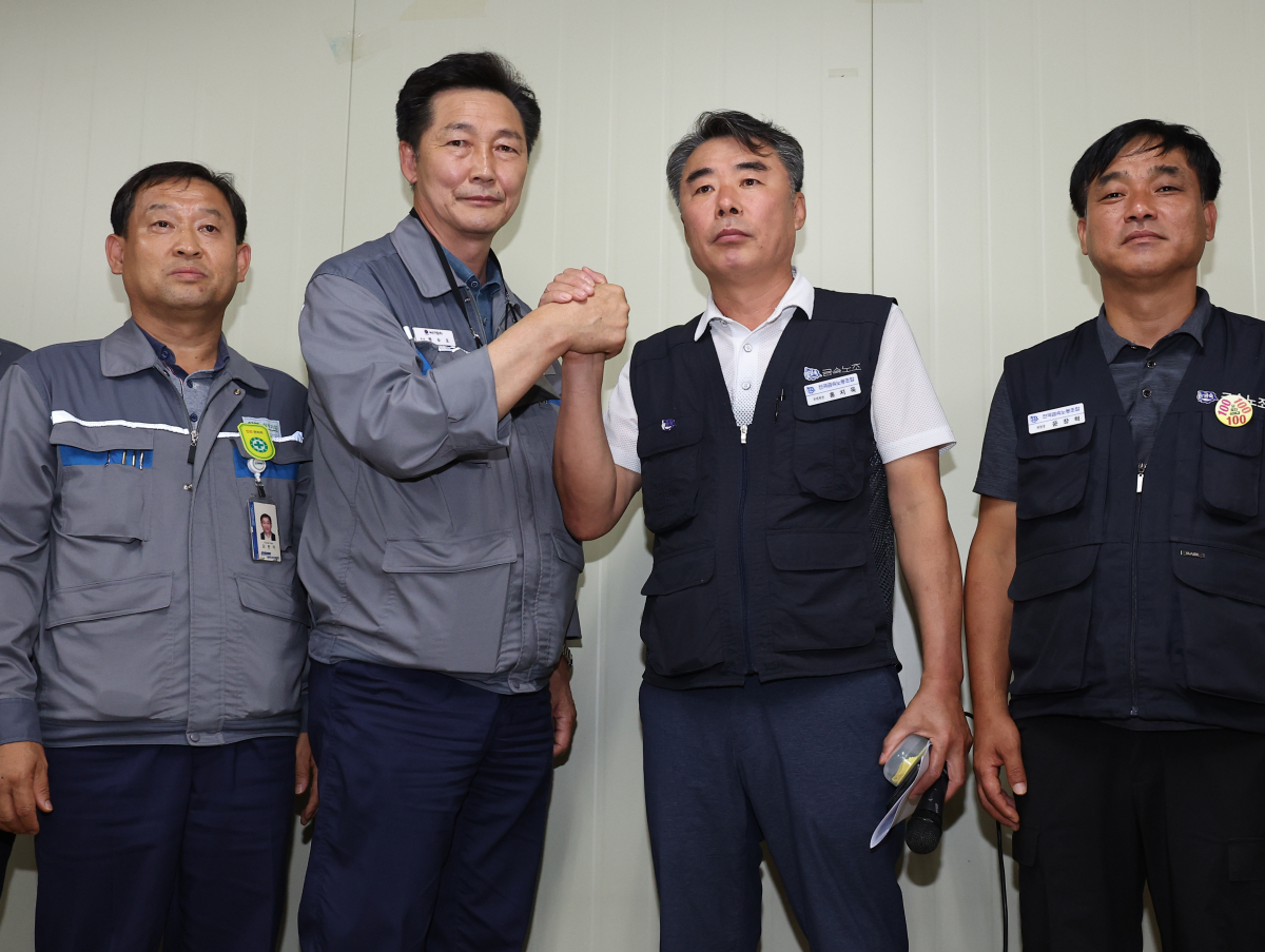 ▲대우조선해양 하청 노사협상이 타결된 22일 경남 거제시 대우조선해양 옥포조선소에서 협력사 대표인 권수오 녹산기업 대표(왼쪽 두번째부터)와 홍지욱 금속노조 부위원장이 손을 맞잡고 있다. (거제=연합뉴스)