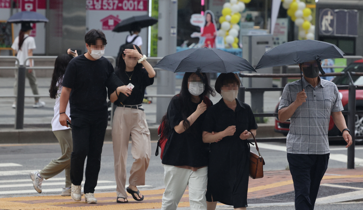 ▲22일 오후 서울 서초구 서울고속버스터미널 인근 횡단보도에서 시민들이 비를 맞으며 길을 건너고 있다. (연합뉴스)