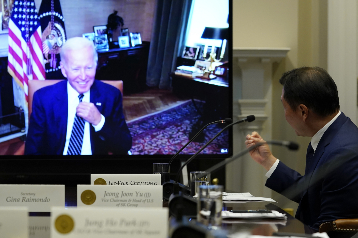 ▲조 바이든 미국 대통령이 26일(현지시간) 백악관 관저 집무실에서 화상 연결을 통해 루즈벨트룸에 있는 최태원 SK그룹 회장의 발표를 웃으면서 경청하고 있다. 워싱턴D.C/AP뉴시스