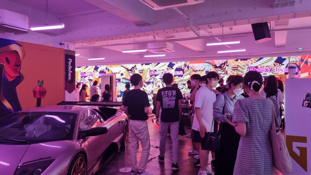 ▲갤러리에 마련된 공간을 관람하는 참가자들. 배경에 젠지와 빗썸이 콜라보한 NFT 아트가 전시돼있다. (박소은 기자 gogumee@)
