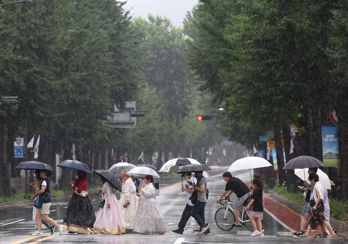 ▲태풍 송다의 영향으로 전국적으로 비가 내린 31일 오후 서울도심에서 시민과 외국인들이 우산을 쓰고 횡단보도를 건너고 있다. (연합뉴스)