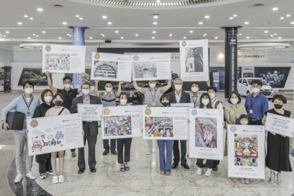 ▲12일 개최된 그림 그리기 대회 시상식에 참여한 GM 한국사업장 리더십 및 직원과 가족들이 그림을 들고 있는 모습. (사진제공=한국지엠주식회사)