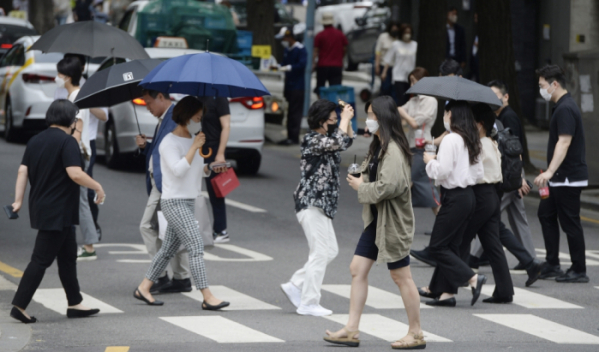 ▲갑작스런 소나기가 내린 13일 서울 중구 청계광장 인근에서 우산을 쓴 시민들이 발걸음을 재촉하고 있다. 조현호 기자 hyunho@ (이투데이DB)