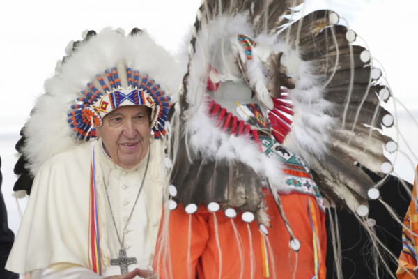 ▲프란치스코 교황(왼쪽)이 25일(현지시간) 캐나다 앨버타주(州)의 매스쿼치스를 방문해 원주민 지도자들이 선물한 머리장식을 착용하고 있다. 매스쿼치스/AP뉴시스