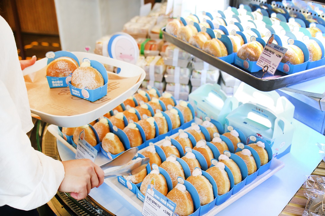 ▲뚜레쥬르 매장에서 한 고객이 퐁신퐁신 크림 도넛을 구매하고 있다.  (사진제공=CJ푸드빌)