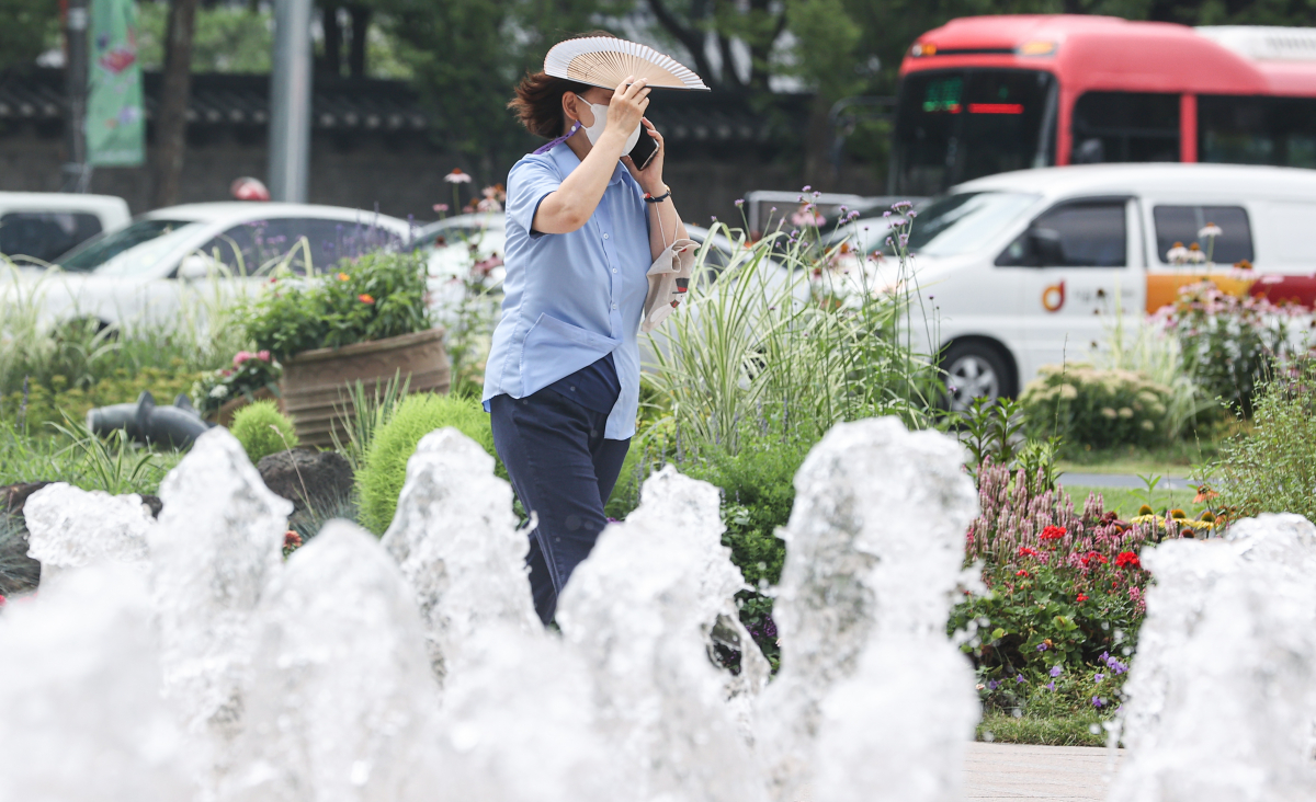 ▲한 시민이 서울 중구 서울광장 분수대에서 부채로 햇빛을 가리고 있다. (연합뉴스)