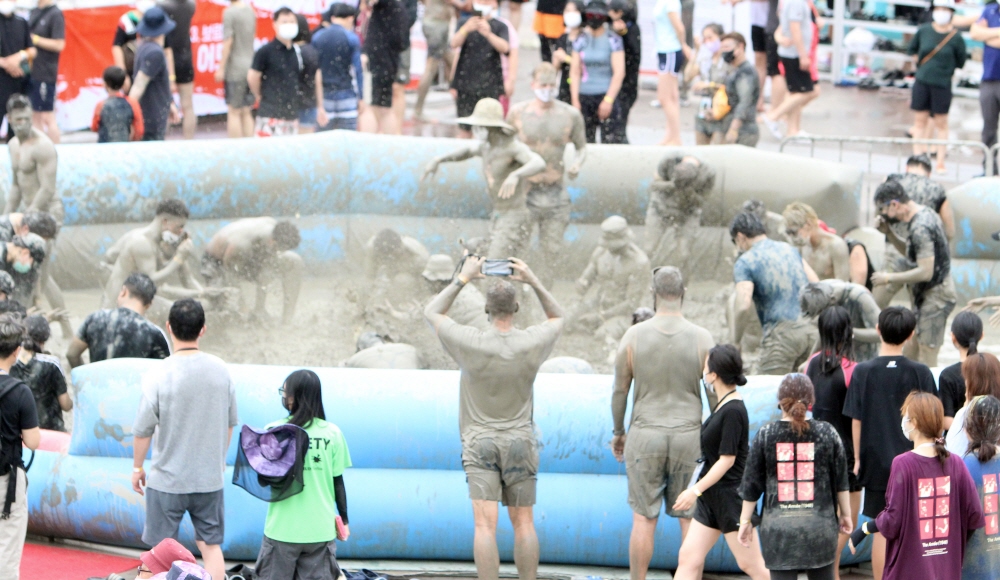 ▲지난달 23일 충남 보령 대천해수욕장 일대에서 열린 '2022 보령해양머드박람회'의 최고 인기관인 머드체험장에서 입장객들이 머드를 뿌리며 놀고 있다. (연합뉴스)